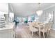 Bright dining room with white table and chairs, hardwood floors at 4950 Gulf Blvd # 104, St Pete Beach, FL 33706