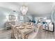 Bright dining room with table and chairs, stylish chandelier, and access to living area at 4950 Gulf Blvd # 104, St Pete Beach, FL 33706