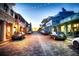 Charming street with brick road, string lights, and parked cars at dusk at 4950 Gulf Blvd # 104, St Pete Beach, FL 33706