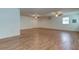 Open-concept living area features gleaming hardwood floors, ceiling fans, windows, and a fresh, neutral color scheme at 911 8Th Sw Ave, Largo, FL 33770