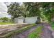 Gray detached garage with a paved driveway and adjacent grassy area at 911 8Th Sw Ave, Largo, FL 33770