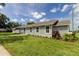 Newly built single-story home with gray siding, stone accents, and landscaped yard at 911 8Th Sw Ave, Largo, FL 33770