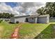 Landscaped backyard with a stone walkway leading to the home at 911 8Th Sw Ave, Largo, FL 33770