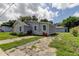 Newly built home with gray siding and stone accents, offering ample parking at 911 8Th Sw Ave, Largo, FL 33770