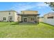 Home's backyard featuring a screened patio and grassy lawn at 3508 Diamond Leaf Ct, Valrico, FL 33594