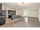 Open concept kitchen and living room with dark cabinets, granite countertops, and wood-look floors at 3508 Diamond Leaf Ct, Valrico, FL 33594