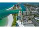 Aerial perspective of condo building, beach, and waterway at 7100 Sunset Way # 405, St Pete Beach, FL 33706