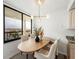 Bright dining area features an oval table, stylish chairs, decorative lighting, and large window with city views at 7100 Sunset Way # 405, St Pete Beach, FL 33706