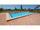 Community pool with brick patio and lounge chairs at 7100 Sunset Way # 405, St Pete Beach, FL 33706