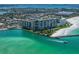 Aerial view of beachfront condo building with ocean and city views, highlighting its prime coastal location at 7100 Sunset Way # 405, St Pete Beach, FL 33706