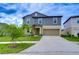 Two-story house with gray siding, tan garage door, and landscaping at 22083 Blazing Star Run, Land O Lakes, FL 34637