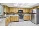 Kitchen with wood cabinets, stainless steel appliances, and tile floor at 2507 Lancaster Dr, Sun City Center, FL 33573