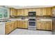 Galley kitchen with wood cabinets and stainless steel appliances at 2507 Lancaster Dr, Sun City Center, FL 33573