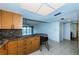 Modern kitchen with wood cabinets, granite counters, and black appliances at 7037 Sunset S Dr # 602, South Pasadena, FL 33707