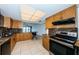 Modern kitchen with wood cabinets, granite counters, and black appliances at 7037 Sunset S Dr # 602, South Pasadena, FL 33707