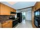 Modern kitchen with wood cabinets, granite counters, and black appliances at 7037 Sunset S Dr # 602, South Pasadena, FL 33707