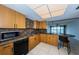 Kitchen with wood cabinets, granite counters, and black appliances at 7037 Sunset S Dr # 602, South Pasadena, FL 33707