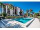 Community pool with surrounding lounge chairs and building view at 7037 Sunset S Dr # 602, South Pasadena, FL 33707