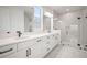 Contemporary bathroom features dual vanities, a glass-enclosed shower, and elegant marble-look tiling for a luxurious feel at 11963 Richmond Trl, Parrish, FL 34219