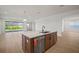 Open floor plan showcasing a kitchen island with seating, stainless steel appliances, and seamless flow to the living area at 11963 Richmond Trl, Parrish, FL 34219