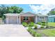 Cute house with a brick facade, attached garage, and nicely landscaped yard at 9717 N Rome Ave, Tampa, FL 33612