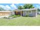 Ranch style home with well-manicured lawn and walkway at 9717 N Rome Ave, Tampa, FL 33612