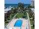 Resort-style pool with lounge chairs, lush landscaping, and ocean view at 19725 Gulf Blvd # 33, Indian Shores, FL 33785