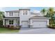 Two-story house with gray siding, two-car garage, and landscaping at 3410 Hazel Hollow Way, Plant City, FL 33565