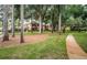 Community walkway winds through lush landscaping and trees at 2200 Tuscany Trce # 21, Palm Harbor, FL 34683