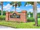 Community welcome sign surrounded by flowers and greenery in front of a scenic lake and fountain at 10022 Bentley Way, Tampa, FL 33626