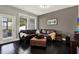 Inviting living room featuring a comfortable sectional, dark hardwood floors, and natural light from a glass door at 10022 Bentley Way, Tampa, FL 33626