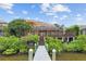 Waterfront home featuring a private dock, screened lanai, and lush landscaping at 1233 Acappella Ln, Apollo Beach, FL 33572
