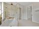 Bathroom featuring a luxurious soaking tub and a glass-enclosed shower with marble wall and upscale finishes at 1233 Acappella Ln, Apollo Beach, FL 33572