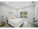 Cozy bedroom with a queen bed, sliding glass doors to the backyard, and neutral decor at 272 Diogenes St, Dunedin, FL 34698