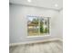 Bright room featuring wood-look floors and large windows overlooking the neighborhood at 272 Diogenes St, Dunedin, FL 34698