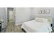 Bright bedroom featuring a queen bed, neutral decor, and wood-look tile flooring at 272 Diogenes St, Dunedin, FL 34698