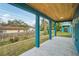 Relax on the covered patio, featuring stylish blue columns and a beautiful wood plank ceiling at 272 Diogenes St, Dunedin, FL 34698