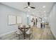 Open floor plan dining room with seating for four, featuring a modern ceiling fan and kitchen view at 272 Diogenes St, Dunedin, FL 34698