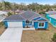Charming blue single Gathering home featuring an attached two car garage and manicured landscaping at 272 Diogenes St, Dunedin, FL 34698