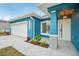 Front exterior of beautiful blue home featuring modern lighting fixtures and gray accents at 272 Diogenes St, Dunedin, FL 34698