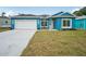 Charming blue single-Gathering home featuring a well-manicured lawn and a two-car garage at 272 Diogenes St, Dunedin, FL 34698