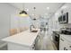 Bright kitchen with a large center island, quartz countertops and stainless steel appliances at 272 Diogenes St, Dunedin, FL 34698