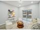 Bright living room featuring hardwood floors, modern furniture, and sliding glass door to backyard at 272 Diogenes St, Dunedin, FL 34698