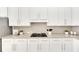 Kitchen with white cabinets, granite countertops, and gas cooktop at 528 Islebay Dr, Apollo Beach, FL 33572