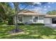 Exterior view of a single story home with a two car garage and mature landscaping at 251 Hidden Brook Dr # 102C, Palm Harbor, FL 34683