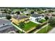 Aerial view of a yellow two-story house with solar panels, a pool, and a fenced backyard at 10820 Carloway Hills Drive, Wimauma, FL 33598