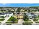 Aerial view of a two-story house with solar panels, and a neighborhood at 10820 Carloway Hills Drive, Wimauma, FL 33598