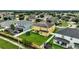 Aerial view of a yellow two-story house with solar panels, a trampoline, and a large backyard at 10820 Carloway Hills Drive, Wimauma, FL 33598