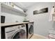 Convenient laundry room with washer, dryer, and shelving at 10820 Carloway Hills Drive, Wimauma, FL 33598