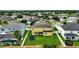 Aerial view of a yellow two-story house with solar panels, a trampoline, and a large backyard at 10820 Carloway Hills Drive, Wimauma, FL 33598